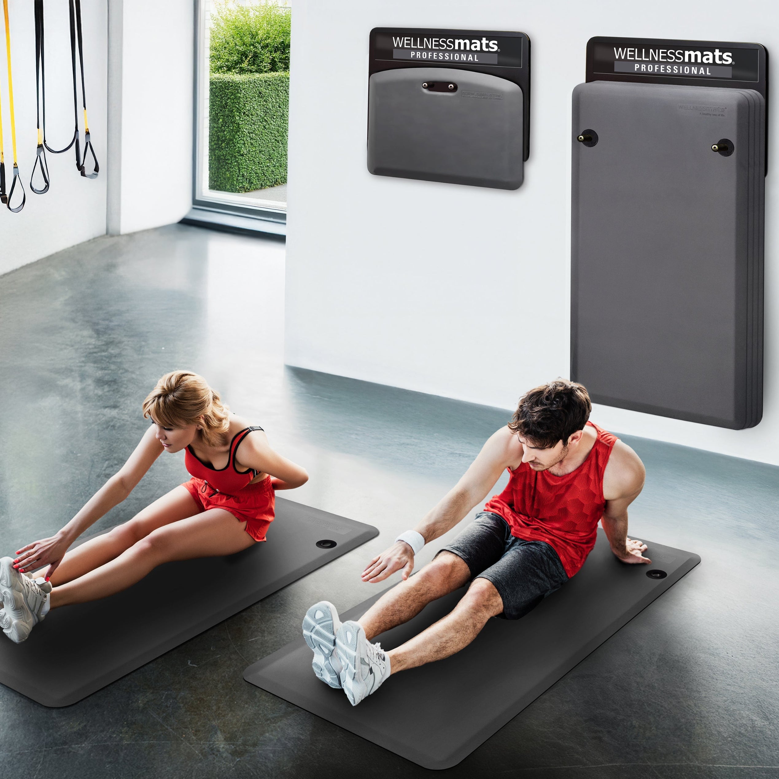 Couple stretching in gym on gray FitnessMats
