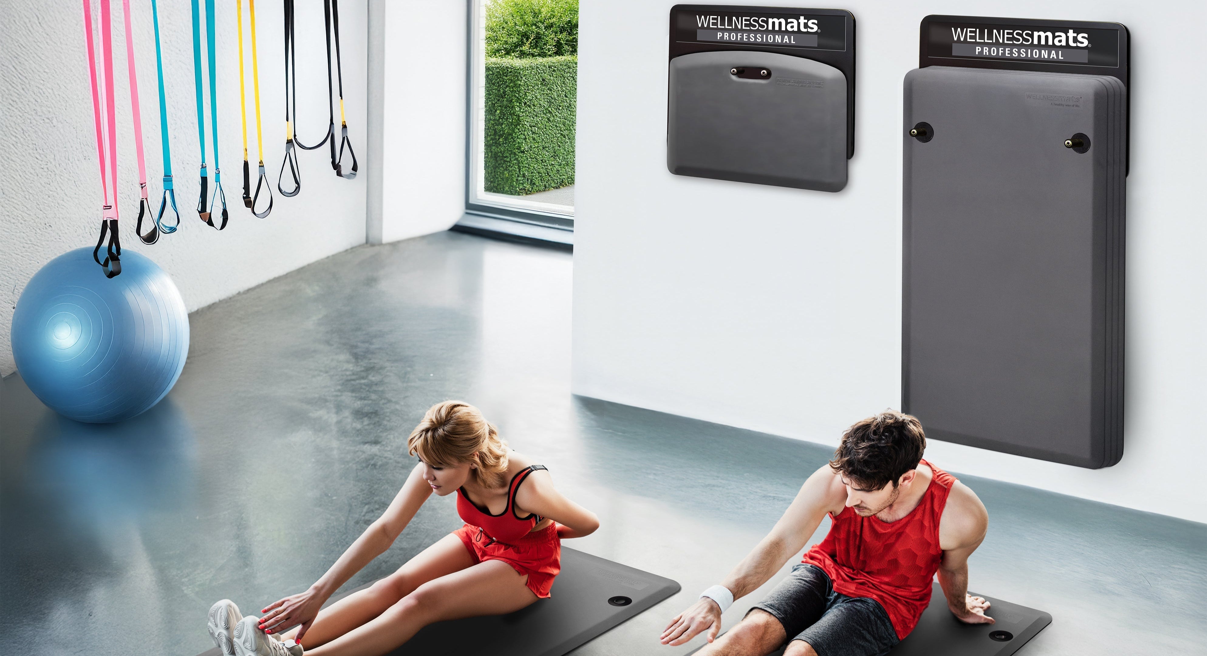 Couple stretching in gym on gray FitnessMats