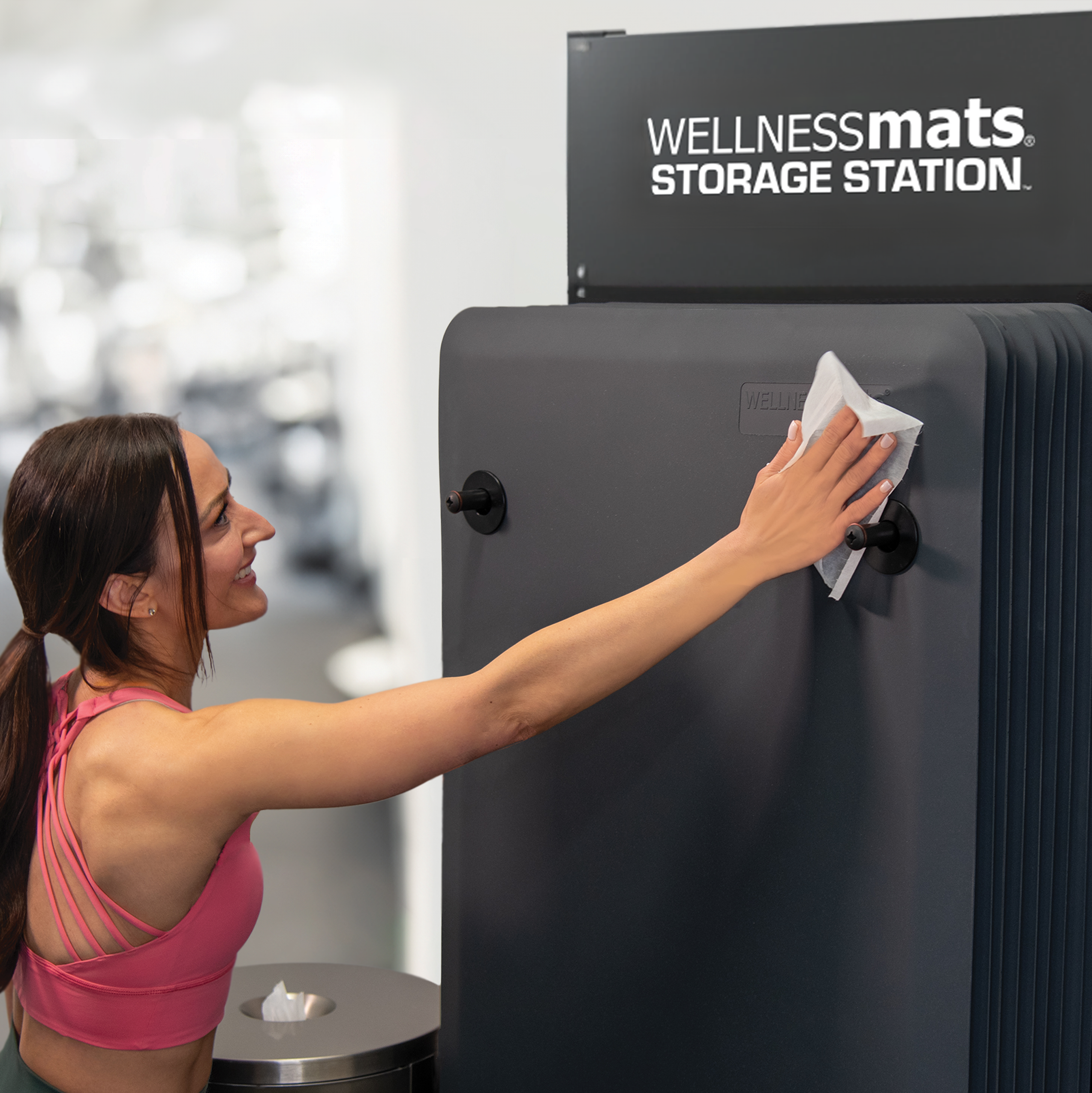 Woman wiping down FitnessMat at a gym