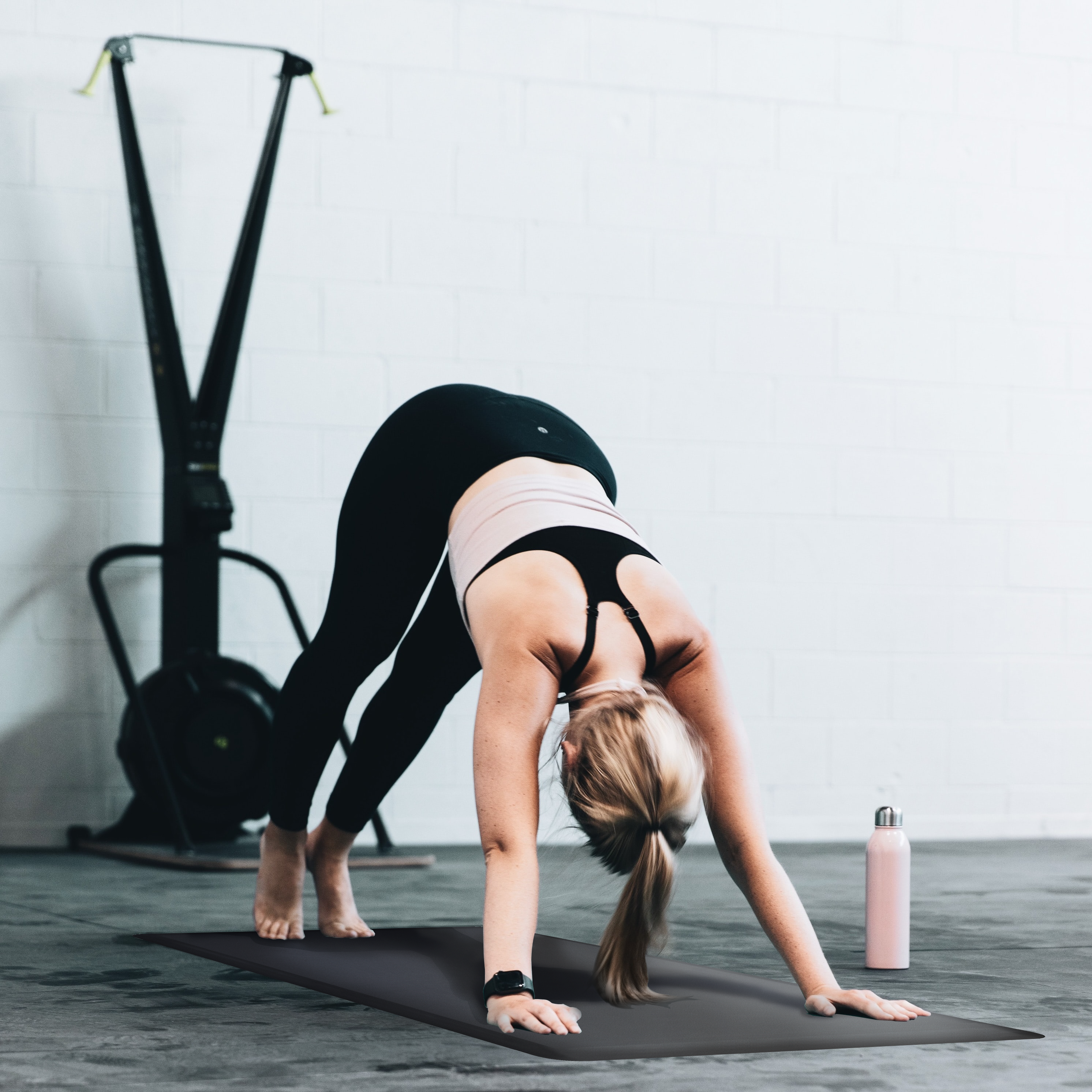 Woman doing yoga pose on Black FitnessMat.